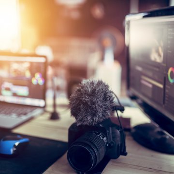 video editing software features wondershare filmora laptop and computer monitor on desk with video editing software on camera on the desk sunny room